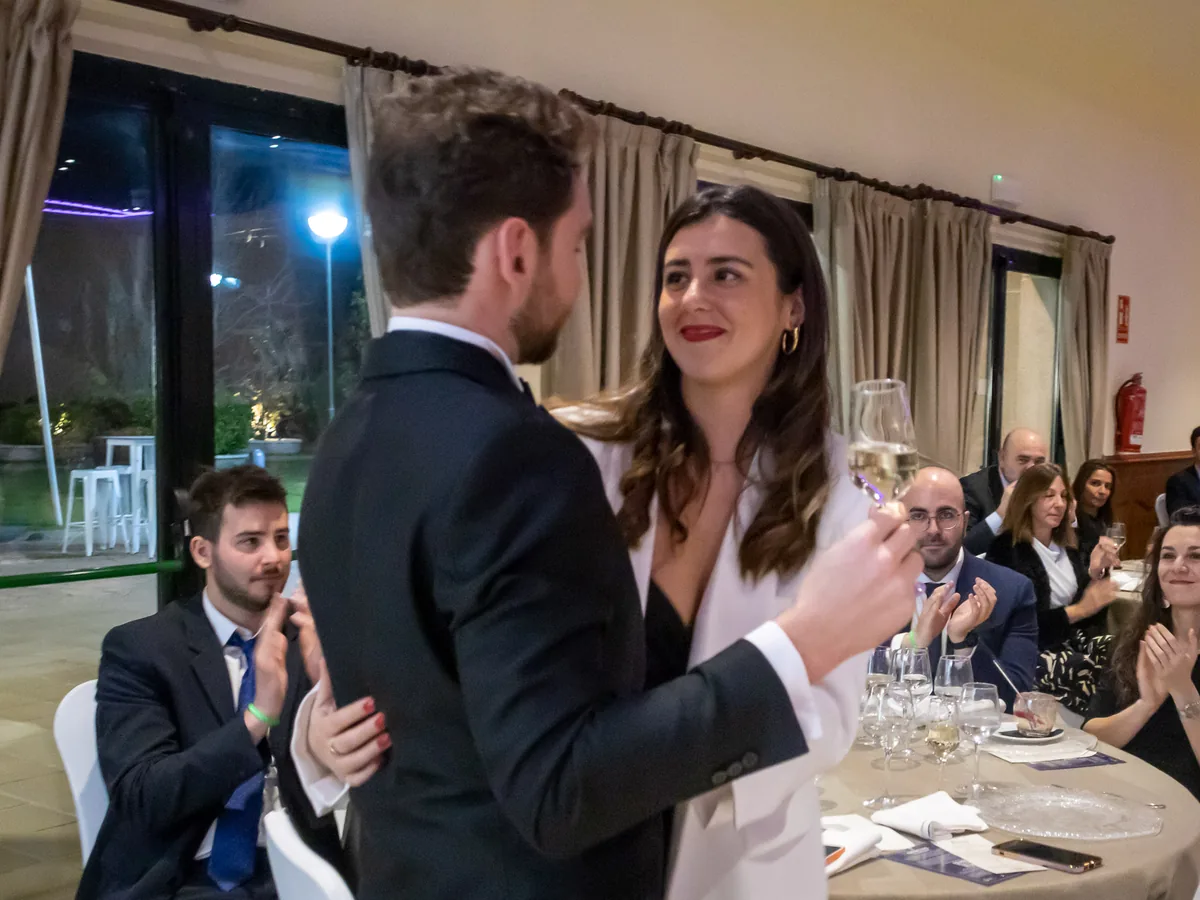Una pareja brinda durante la cena de gala, rodeada de invitados que aplauden